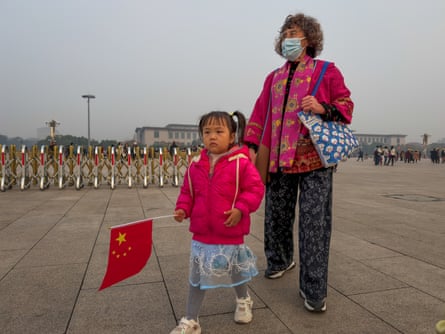 Child holds Chinese flag at Tiananmen Square in Beijing