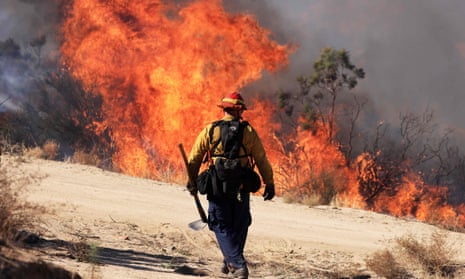 A firefighter walks towards a wildfire in California.