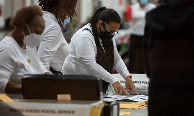 Election workers inspect absentee ballots on 4 November 2020 in Detroit, Michigan.
