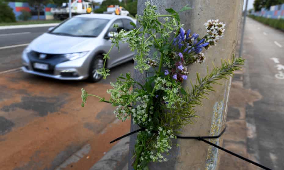 Flowers are viewed at the scene of a fatal car accident. 