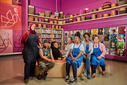 group standing and seated posing for picture among pink walls