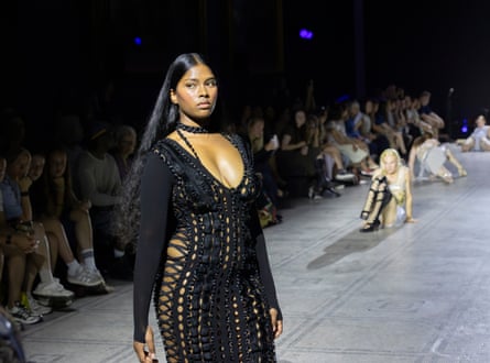 Model wearing a black laced dress on the catwalk