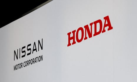 Logos of Nissan Motor Corporation and Honda at a joint press conference on their merger talks, in Tokyo, Japan
