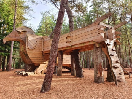 A huge wooden bird climbing frame, set in woodland