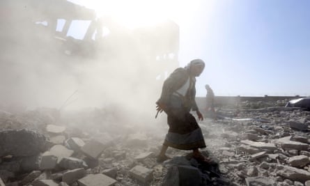 Armed men inspect a Houthi-held detention center after it was hit by alleged Saudi-led airstrikes in Dhamar, Yemen, 1 September 2019.