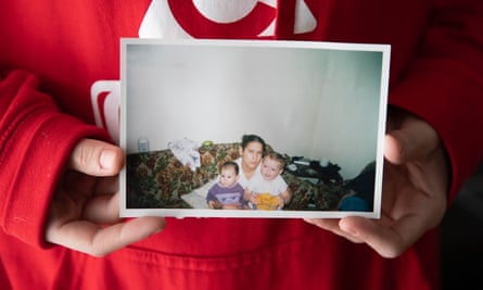 Harris holds a photo of herself (right), with her her little sister and their mom.