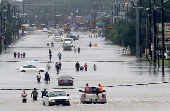 People walk through the flooded waters of Telephone Road in Houston.