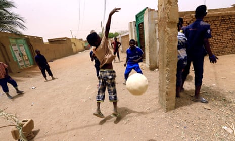 Children play football on the street in Khartoum