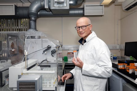 A man wearing a lab coat standing next to scientific equipment