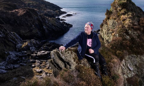 Marion Stevenson sitting on the rocky coastline of the Isle of Gigha.