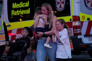 Mother cradles child next to ambulance