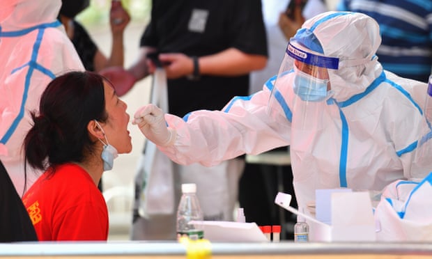 A health worker tests a woman for Covid-19 in China’s Hunan province