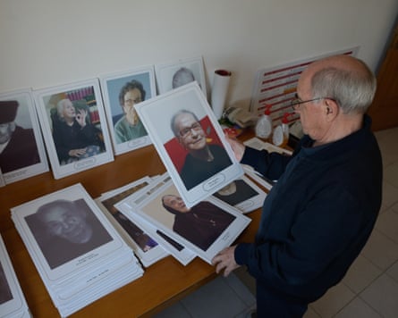 Tore Pedde looks at photos of some of the elderly citizens of Balotana.
