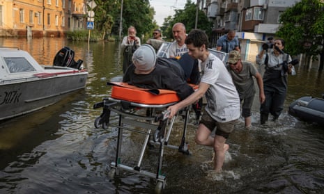 Volunteers haul a woman on a stretcher as she been evacuated from a flooded neighbourhood on the left bank Dnipro river, in Kherson.