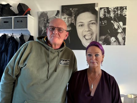 Man and woman stand in front of photo of their son.
