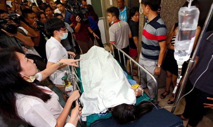 Medics rush an injured person into the emergency room at Police Hospital, where staff were forced to call for Chinese interpreters to help treat foreigners