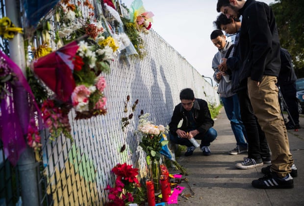 People place flowers and notes at a makeshift memorial in Oakland, near the site of the devastating fire.