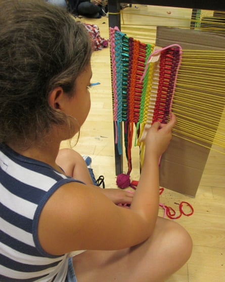 A student learns to weave with yarn made from old clothes.