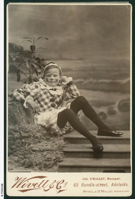 Black and white photo of a young boy in a clown costume