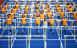Volunteers moving the hurdles for the men’s and women’s races at Alexander Stadium.