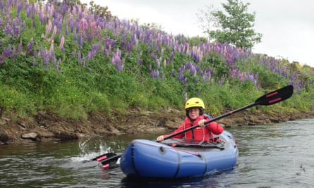 Wild lupins line the Tay’s banks as one of Kate Eshelby’s children paddles downstream
