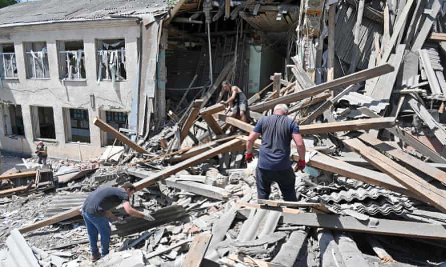 Workers of the Liubotinsky Lyceum of Railway Transport and local residents dismantle the ruins of an administrative building, as result of the explosion of a Russian rocket, in Lyubotyn, Kharkiv region, on June 20, 2022.