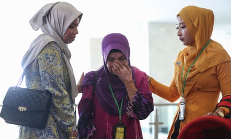 Sarah Nor (centro), la madre de Norliakmar Hamid, pasajero del vuelo MH370, recibe consuelo en la sede del Ministerio de Transportes en Putrajaya.