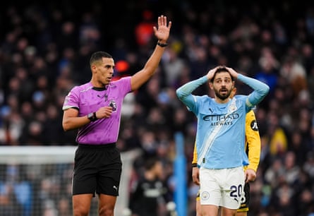 Referee Farai Hallam makes an announcement of no penalty, much to the chagrin of Bernardo Silva