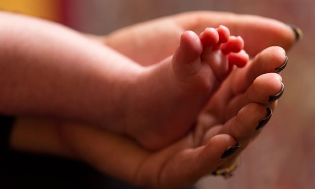 A hand and the feet of a baby
