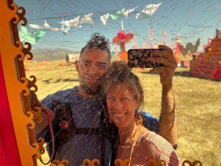 A woman and man pose for a mirror selfie in the middle of the desert