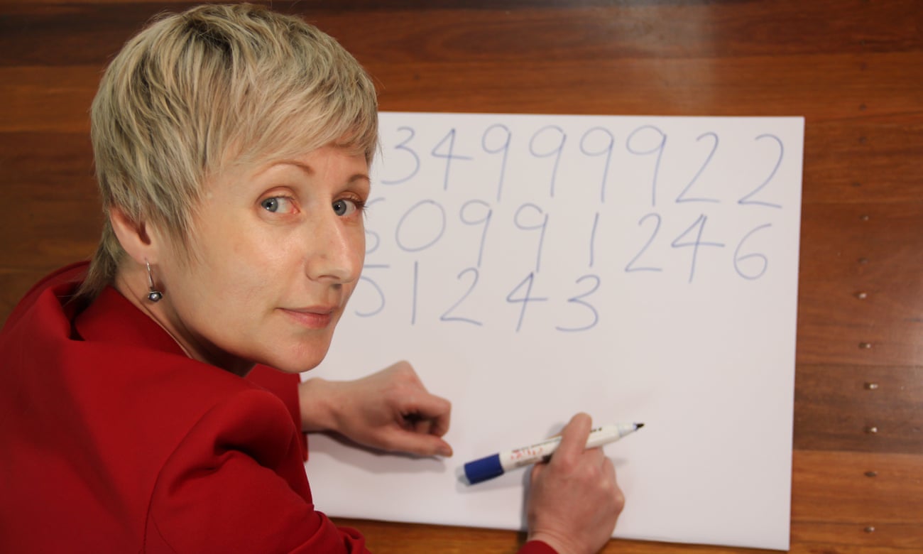 Anastasia Woolmer writing the digits of pi on a large piece of cardboard