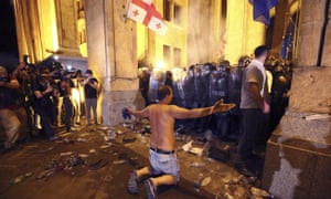 An opposition demonstrator stands in front police line outside Georgia’s parliament.