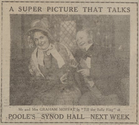 A sepia-toned newspaper advertisement featuring an image of a smiling man and a woman dressed in Victorian costumes. It reads at the top: 'A SUPER PICTURE THAT TALKS'. Below the photo it reads: 'Mr and Mrs GRAHAM MOFFAT in 'Tills the Bells Ring' at'