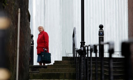 An elderly woman walks in Stockport town centre. 