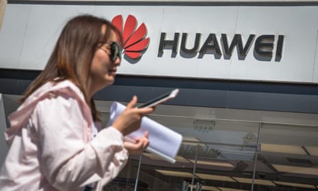 A woman walks past a Huawei store in Beijing, China, after Google halted business with the Chinese phonemaker.