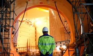 An EDF worker stands at the construction site of the third-generation nuclear reactor at Flamanville, France