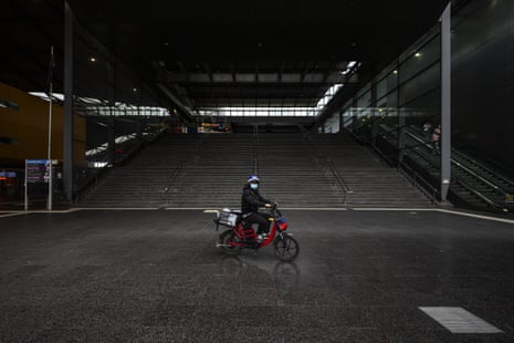 A food delivery rider rides past a deserted Southern Cross station in Melbourne.