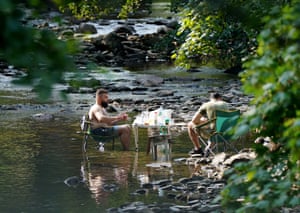 People enjoy a barbecue in a river near the village of Luss, on the west bank of Loch Lomond
