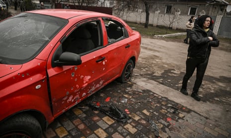 A woman beside a damaged car after the attacks in Kramatorsk