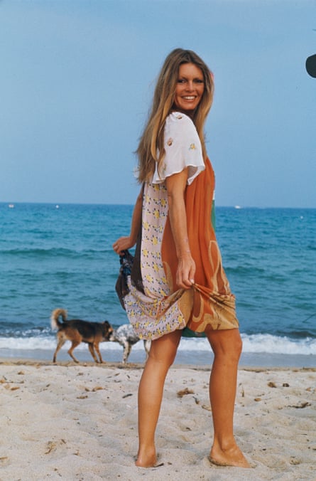 Maximum coverage. Brigitte Bardot in a colourful T-shirt dress pictured on a beach in Saint Tropez in 1974.