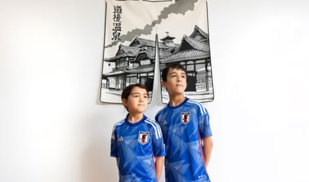 England’s united nations of football: 32 teams, one World Cup – and a lot of excited kids | World Cup 2022 20 Iena and Yuji Mirto wearing blue Japan shirts and standing in front of a hanging depicting a pagoda