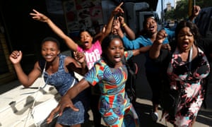 Zimbabweans celebrate in the morning sun in Harare after Robert Mugabe resigned as president.