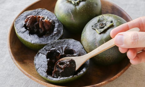 Black sapote chocolate pudding fruit on a wooden plate.