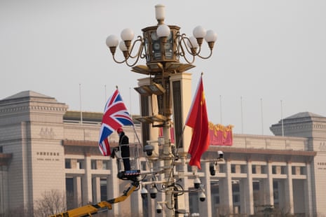 A worker sets up a British national flag next to a Chinese national flag ahead of Keir Starmer’s visit to Beijing.