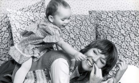 Rachael Stirling, as a baby, in a dress on the back of Diana Rigg, lying on a sofa