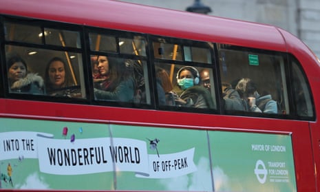 A woman wearing a face mask on a bus in London
