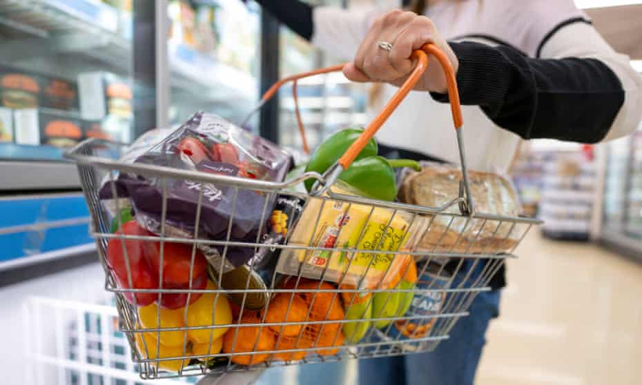 Someone holds a basket of goods in a supermarket in Cardiff, Wales, in 2022