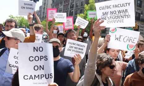A group of people hold mostly printed-out black-on-white signs that say 'No cops on campus,' 'We care,' etc.