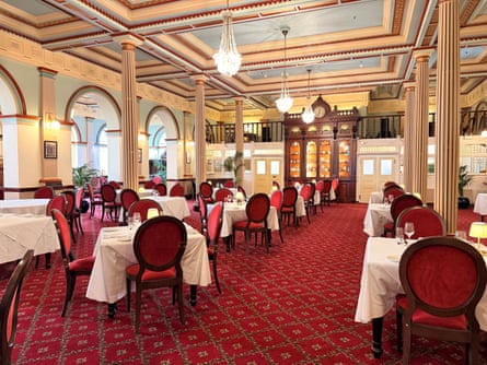 Tables and chairs in a grand dining room.