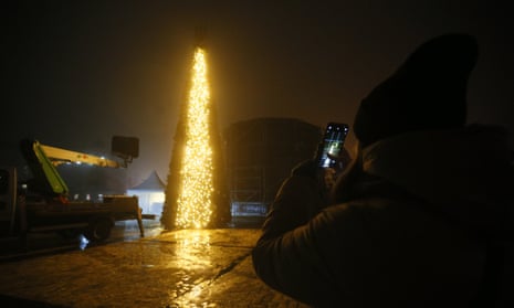 A person takes a photo as the Christmas tree is set up in Kyiv’s Sophia Square